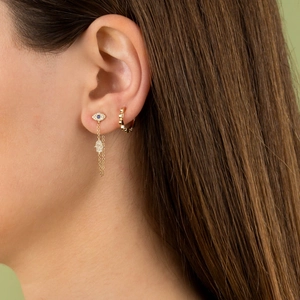 Chic evil eye gold earrings with chain link and blue zircon stones on a model