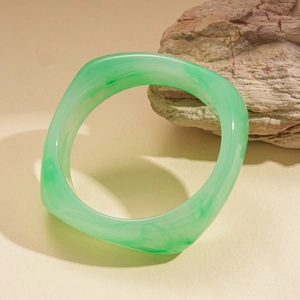 Detailed view of square green resin bangle with translucent marbled pattern texture