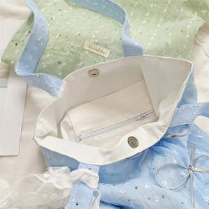 Detail showing the inner lining, lace trim and sequin mesh fabric of this blue tote bag