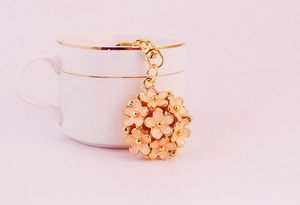 Detailed close-up of a 3D pink daisy flower ball keychain with gold-plated metal hardware