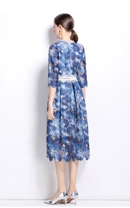 Back view of a mid-length lace dress with blue floral patterns and white hollow lace trim