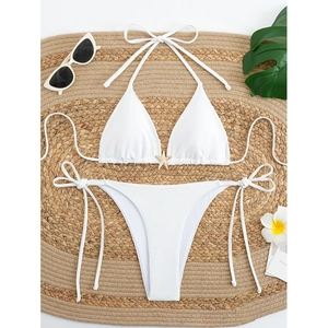 White halter bikini set with starfish detail on a round straw mat for summer beach vacation
