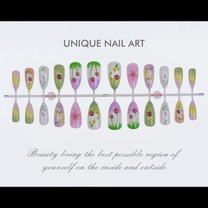 Detailed flat lay of almond press-on nails with hand-painted strawberry and ladybug motifs