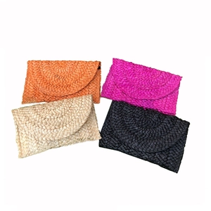 Handmade corn husk envelope clutch bag in orange, pink, natural, and black straw weave