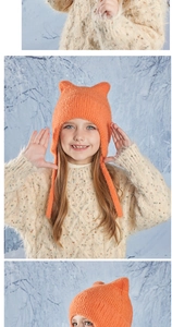 Detail of orange knitted kids hat with cat ears and long straps for winter warmth