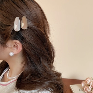 Détail de barrettes ovales nacrées avec gravure France Handmade portées par un mannequin