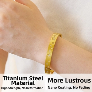 Detailed view of gold stainless steel star bangle with zircons on model wrist