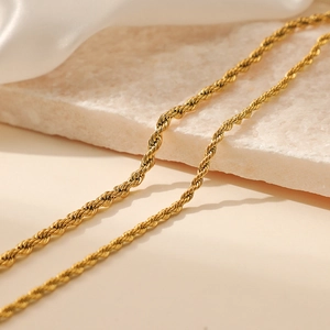 Elegant 3mm/4mm gold stainless steel twist rope chain necklace displayed on a stone