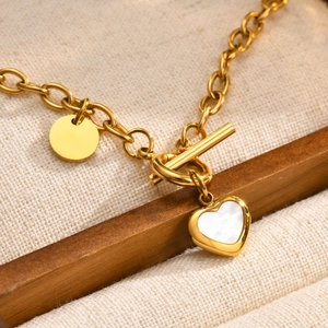 Detailed macro shot of gold heart pendant and shell inlay with OT clasp closure