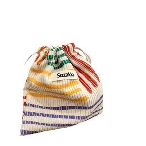 Colorful striped corduroy drawstring bag for cosmetics and gift storage on white background
