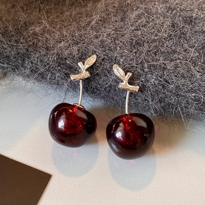 Elegant deep red resin cherry earrings with silver stems on soft grey knit fabric