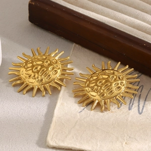 Detailed view of 18K gold plated sun stud earrings with hammered texture on beige paper