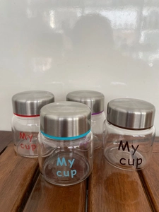 Detailed view of four glass jars with colored silicone seals and My cup engraving