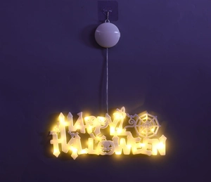 Close-up of Happy Halloween LED suction cup light with warm yellow glow on purple wall