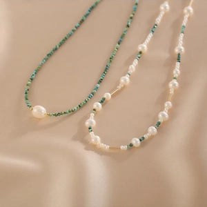 Detail view of double-layer natural pearl and turquoise necklace on champagne velvet