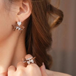 Detail of cute brown dachshund dog earrings and ring set with heart-shaped zircon stones