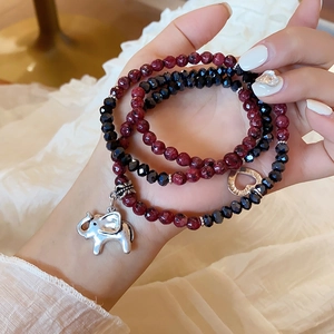 Close-up of layered rhodochrosite beads with silver elephant and heart charms