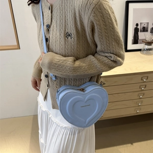 Minimalist light blue heart-shaped crossbody bag with embossed patterns and gold hardware