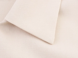 Close-up macro of beige linen fabric texture with detailed cross-weave pattern for women shirt