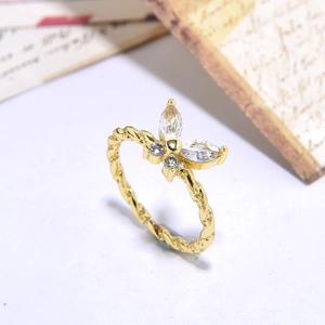 Detail of a gold butterfly ring featuring zircon pavé stones and a twisted band design