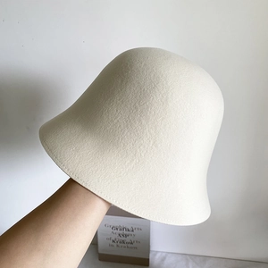 Détail d'un chapeau cloche en feutre de laine crème montrant sa texture premium