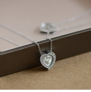 Macro shot of silver heart pendant with micro-pave zircon setting and detailed texture