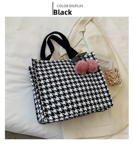 Detail of canvas tote bag with houndstooth pattern and pink plush cherry charm