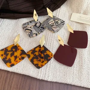 Three pairs of vintage geometric resin earrings with diamond patterns and gold studs