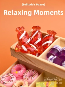 Macro shot of miniature resin Christmas candy and chocolate donuts on a wooden organizer