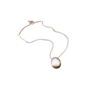 Collier minimaliste argenté avec pendentif ovale et texture métallique brossée mate