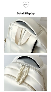 Detail of pearlescent white backpack with thick handle and woven zipper pullers