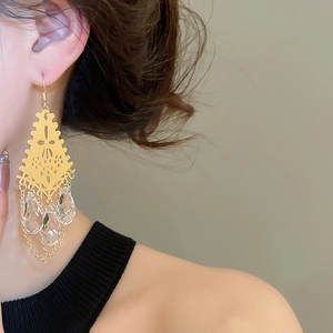 Close-up of French vintage gold hollow earrings with crystal drops and long tassels
