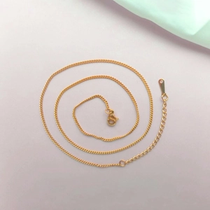Macro detail of gold-plated stainless steel chain with lobster clasp and extender