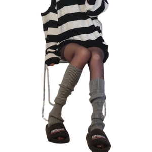 Gray Y2K knitted leg warmers styled with fuzzy slippers for a trendy winter look