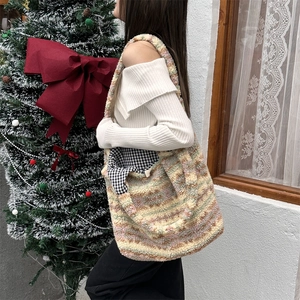 Detailed texture of colorful striped plush tote bag with festive Christmas decor background