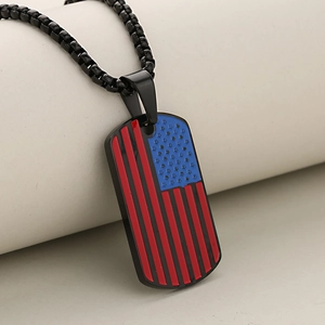 Oval American flag dog tag pendant in black stainless steel on a textured background