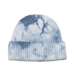 Detailed texture of thick ribbed knit fabric on blue and white tie-dye beanie hat