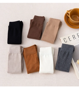 Flat lay of seven pairs of knit calf socks in assorted neutral colors with coffee decor