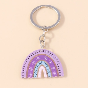 Rainbow acrylic keychain with purple stripes, white stars and black dots on a beige base