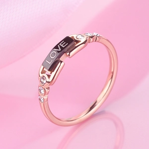 Rose gold titanium steel ring with black rectangular Love plate and clear zircons