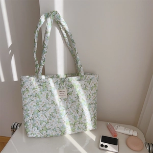 Close-up of quilted floral cotton tote bag with vintage French label and skincare items