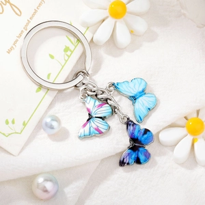 Detailed view of colorful enamel butterfly pendants on a silver metal keychain ring