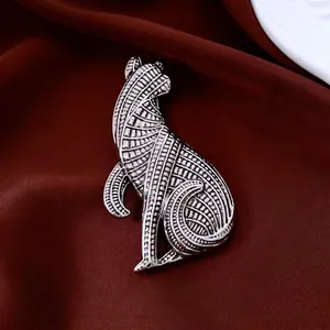 Vintage silver cat brooch with geometric texture on red silk background