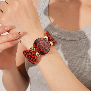 Detailed view of leopard print acrylic circular bracelet on wrist with gold accents