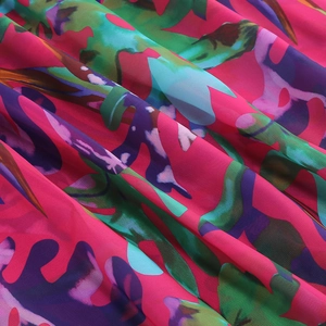Detailed macro view of tropical floral chiffon fabric with pink, blue and green patterns