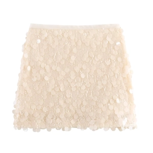 Detailed view of oversized champagne paillettes on an elegant mini sequin skirt