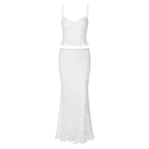 Detail of white two-piece set featuring delicate lace patterns and ruffle hem design