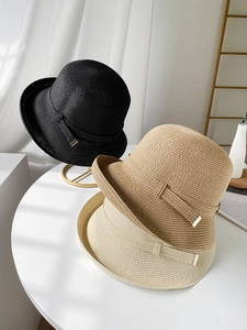Dettaglio di tre cappelli di paglia in nero, kaki e beige con fibbia in metallo oro