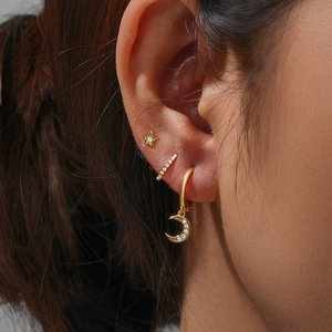 Detail view of gold-plated 925 silver star and moon earrings set with pavé cubic zirconia