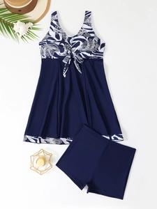 Flat lay of a printed tankini set with bow tie detail and matching swim bottoms